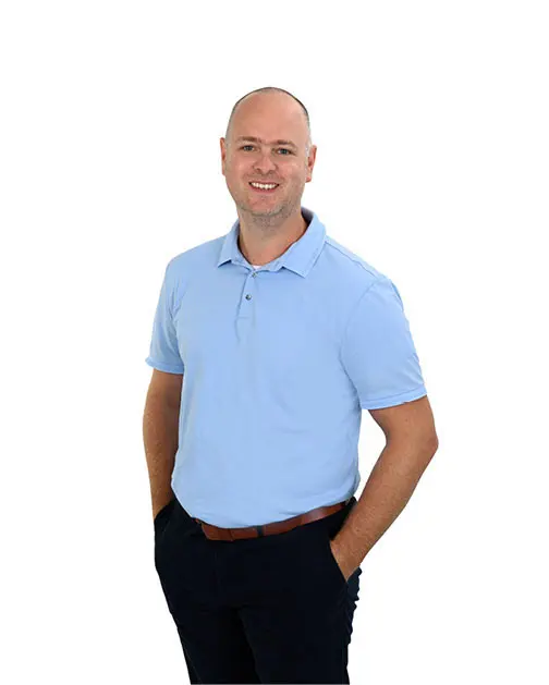 Man met een lichtblauwe polo, voor een witte achtergrond.