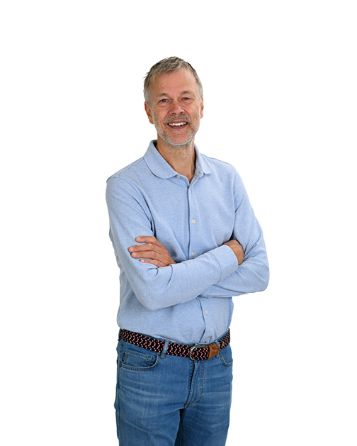 Lachende man met gekruiste armen en een lichtblauwe blouse.