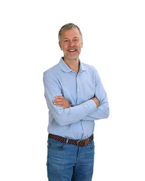 Lachende man met gekruiste armen en een lichtblauwe blouse.