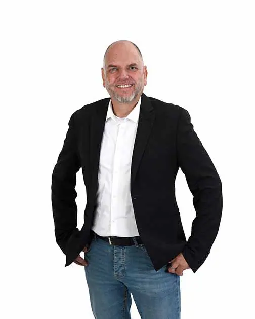 Lachende man met een witte blouse en een colbert, voor een witte achtergrond.