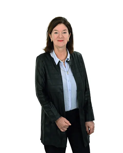 Vrouw met een lichtblauwe blouse en een lang zwart vest.