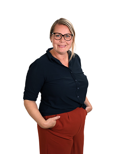 Blonde vrouw met bril en zwarte blouse.
