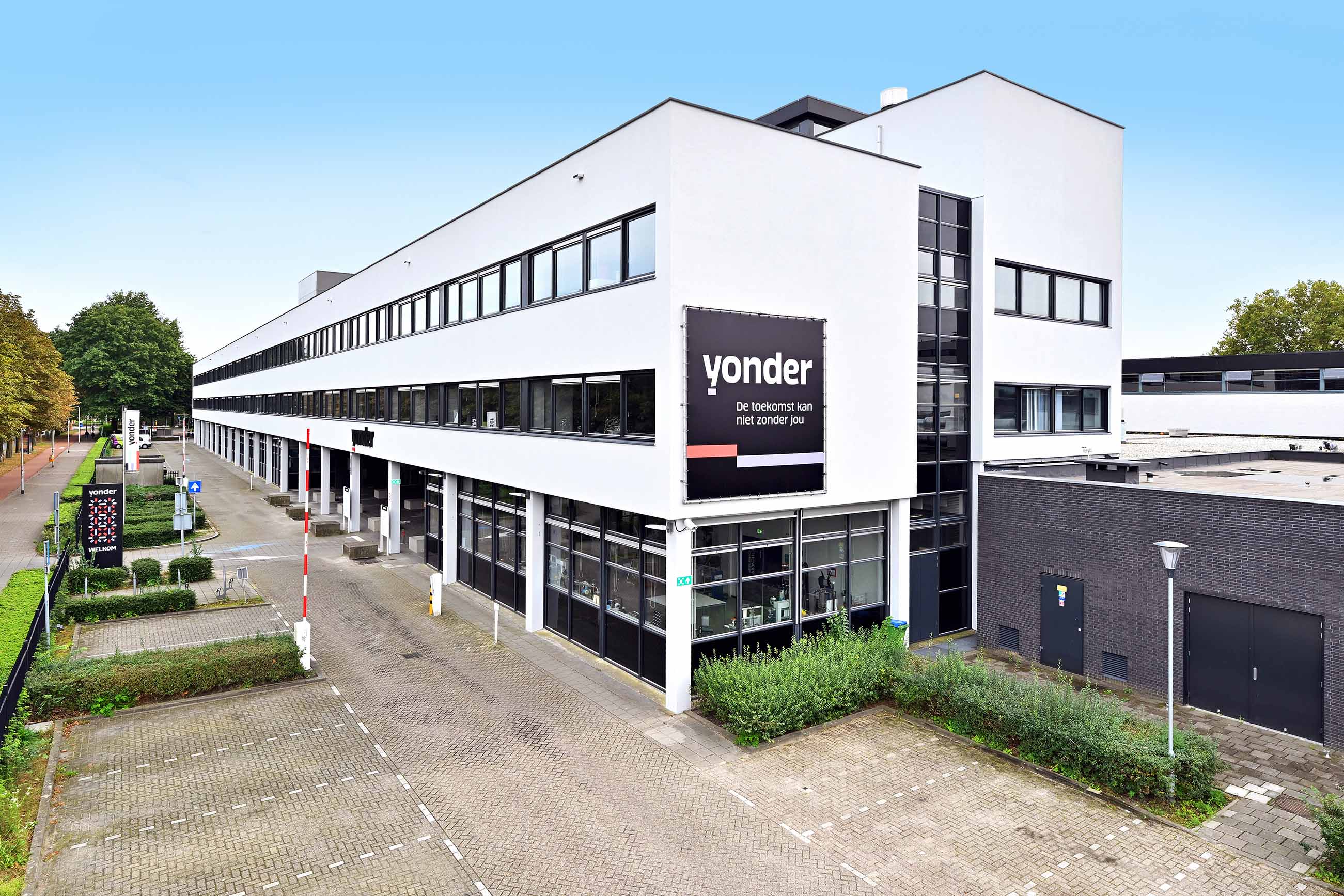 Zijaanzicht schoolgebouw met Yonder spandoek