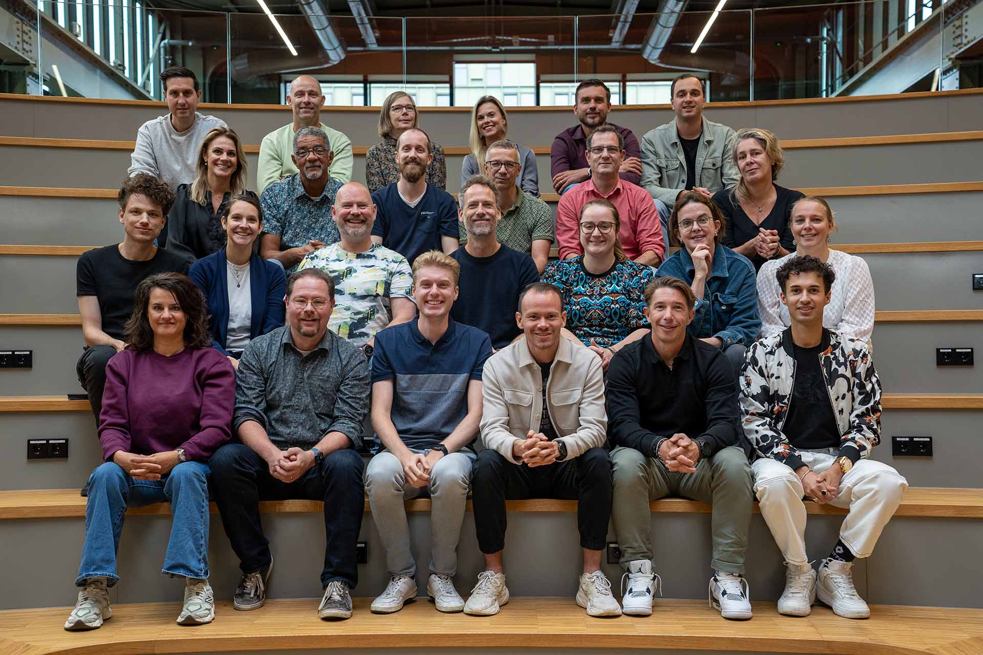 Groep mensen op houten tribunes.
