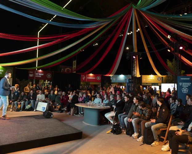 Zaal met mensen die luistert naar een presentator van Wereldcafé FF concreet