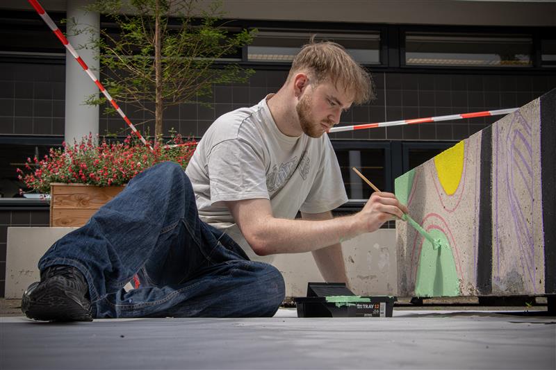 Yonder student die betonblokken aan het schilderen is