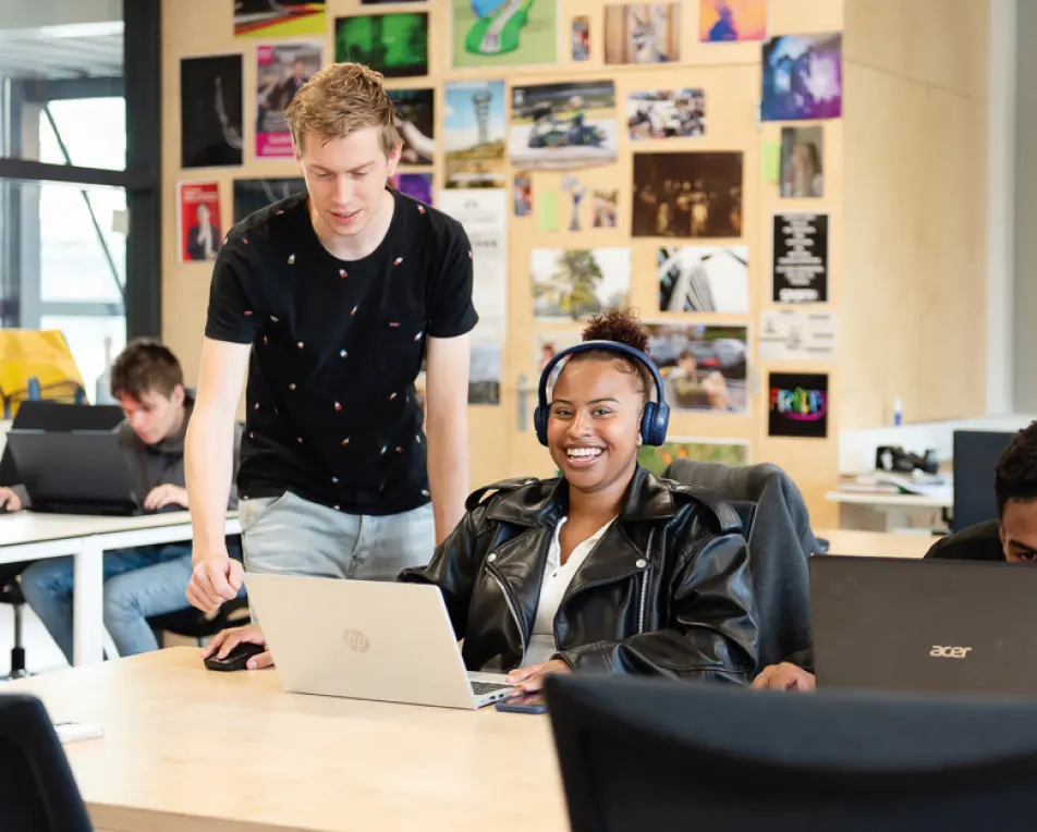 jonge vrouw in een lokaal achter laptop met koptelefoon op