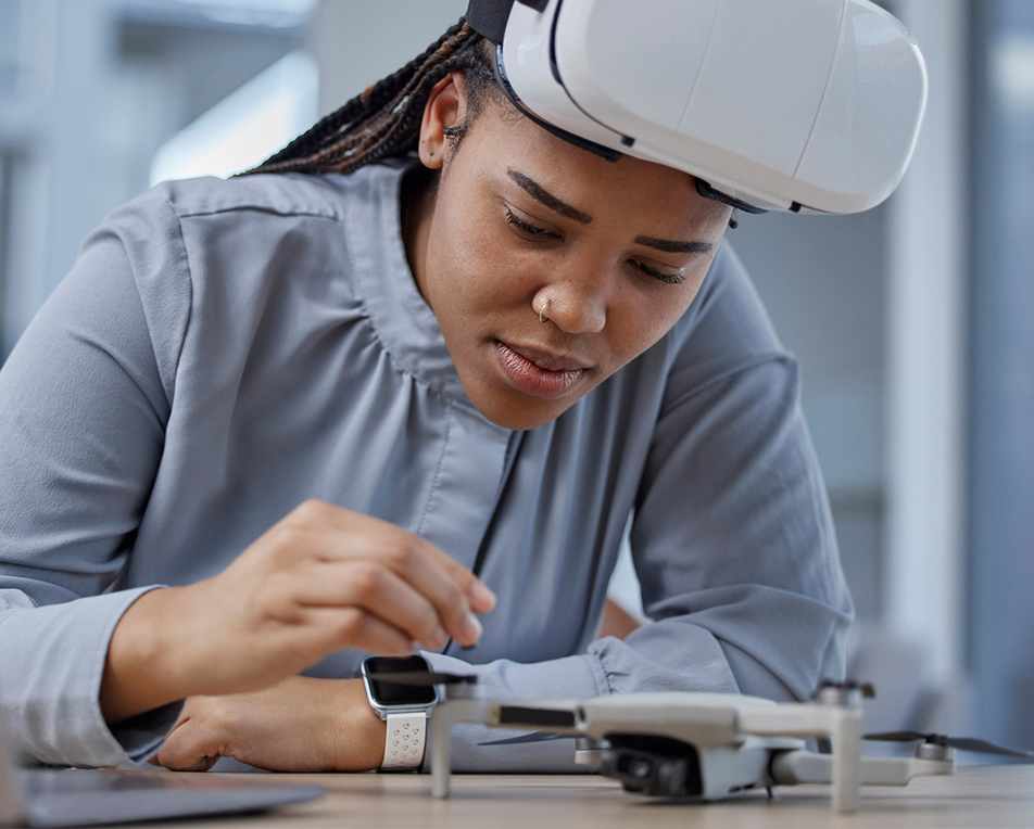 Meisje met VR bril die aan een drone aan het werken is