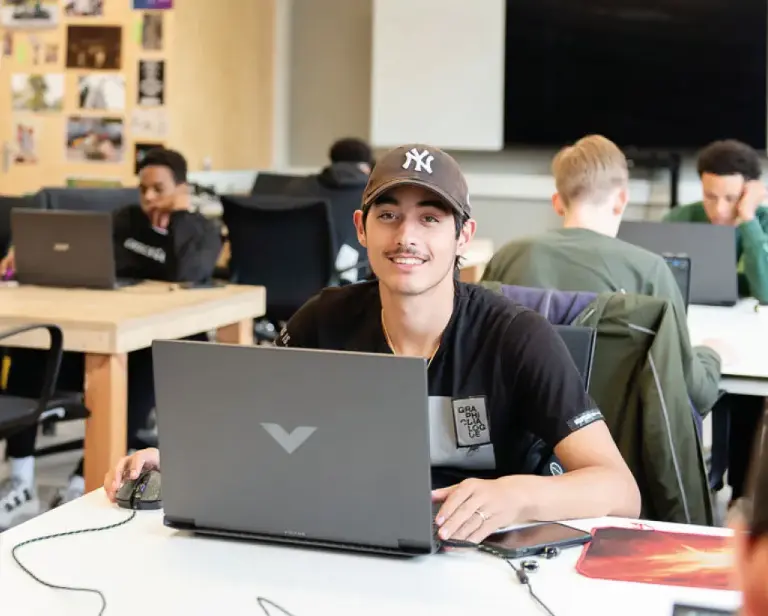 jongen in klaslokaal achter laptop