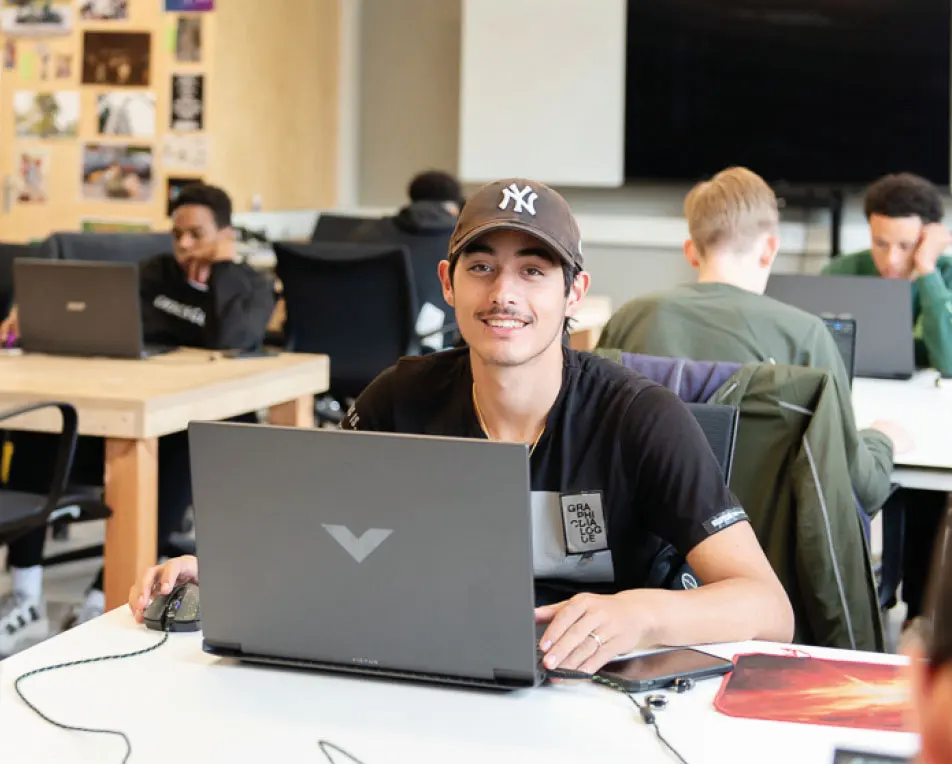 jongen in klaslokaal achter laptop
