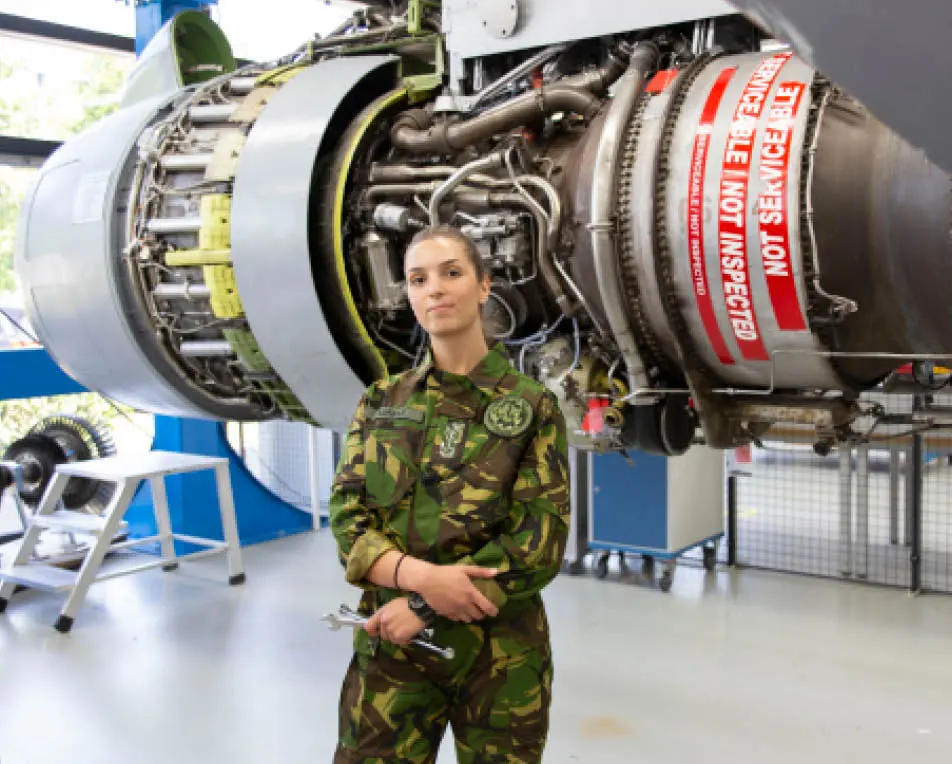Vrouw staat in legeroutfit voor een vliegtuig