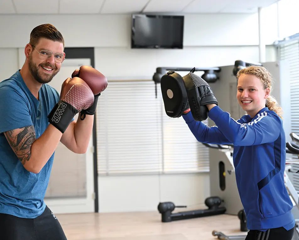 leraar met leerling aan het sporten (boksen)