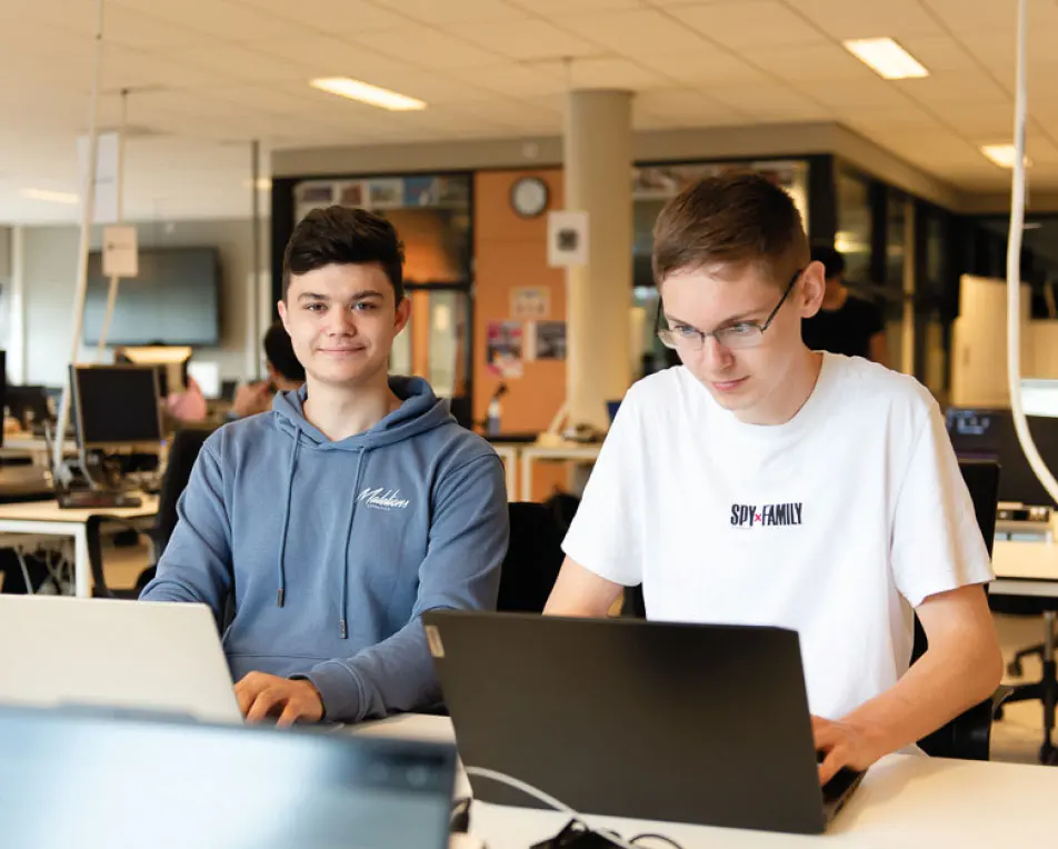 Twee personen werken aan een computer.
