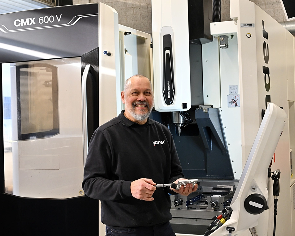 lachende man voor een CNC freesmachine metaal