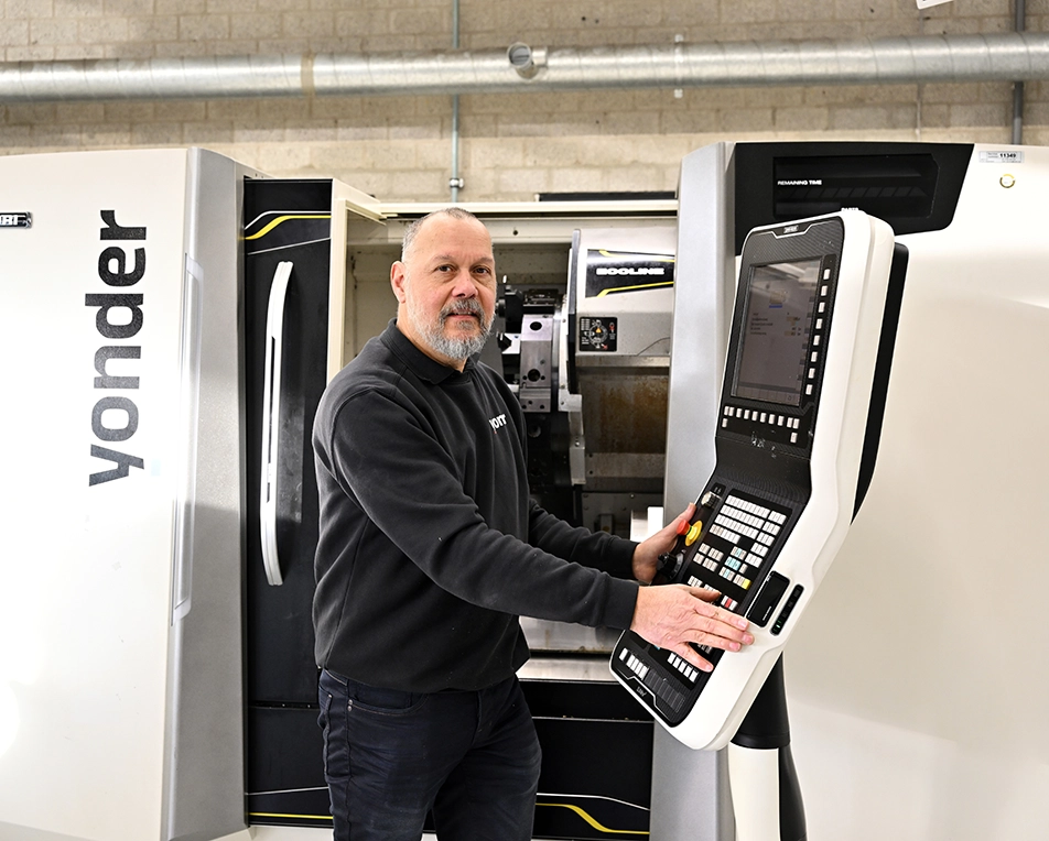 Man aan CNC draaimachine die alles instelt