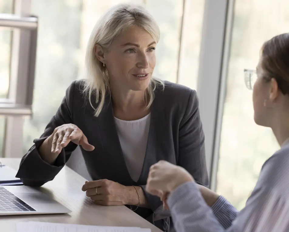 Twee personen zijn met elkaar in gesprek in kantoor.
