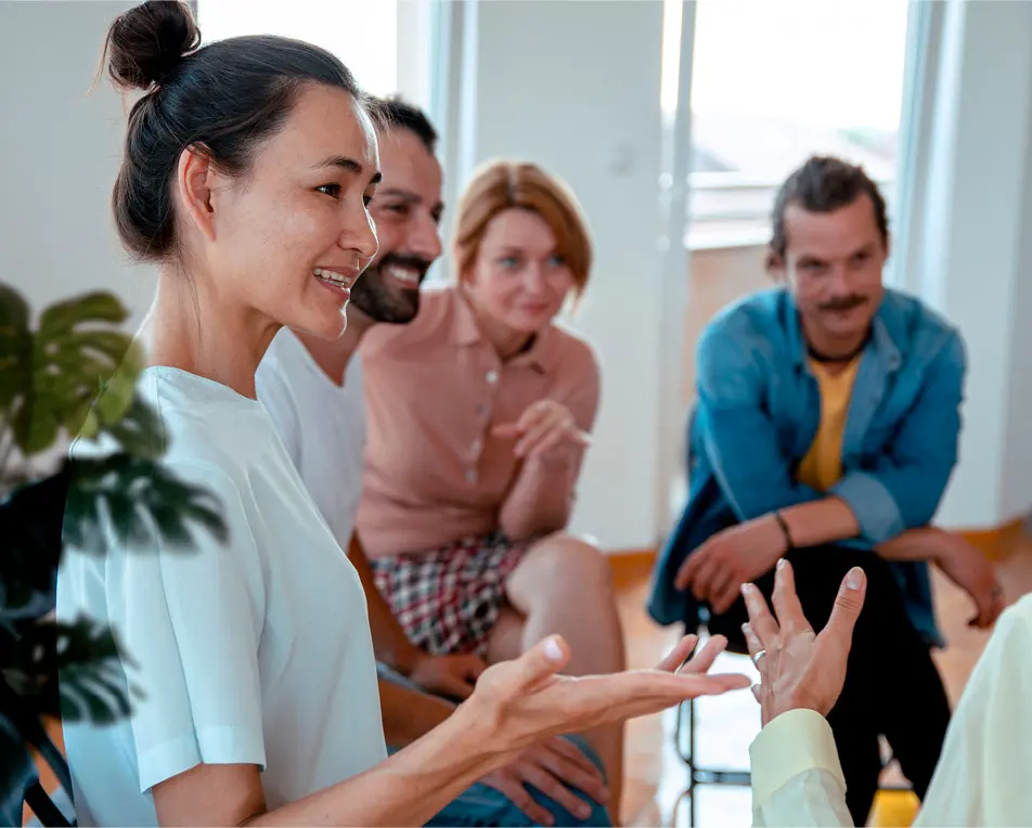 Groep personen zijn met elkaar in gesprek in lichte ruimte