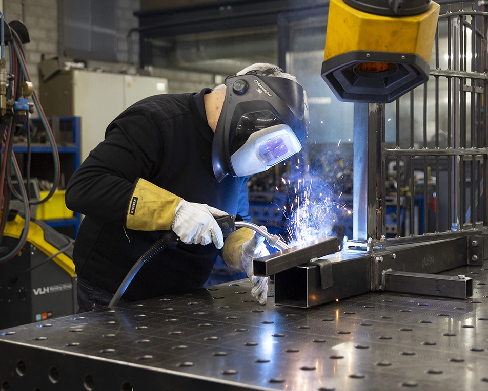 Man met laskap die aan het lassen is