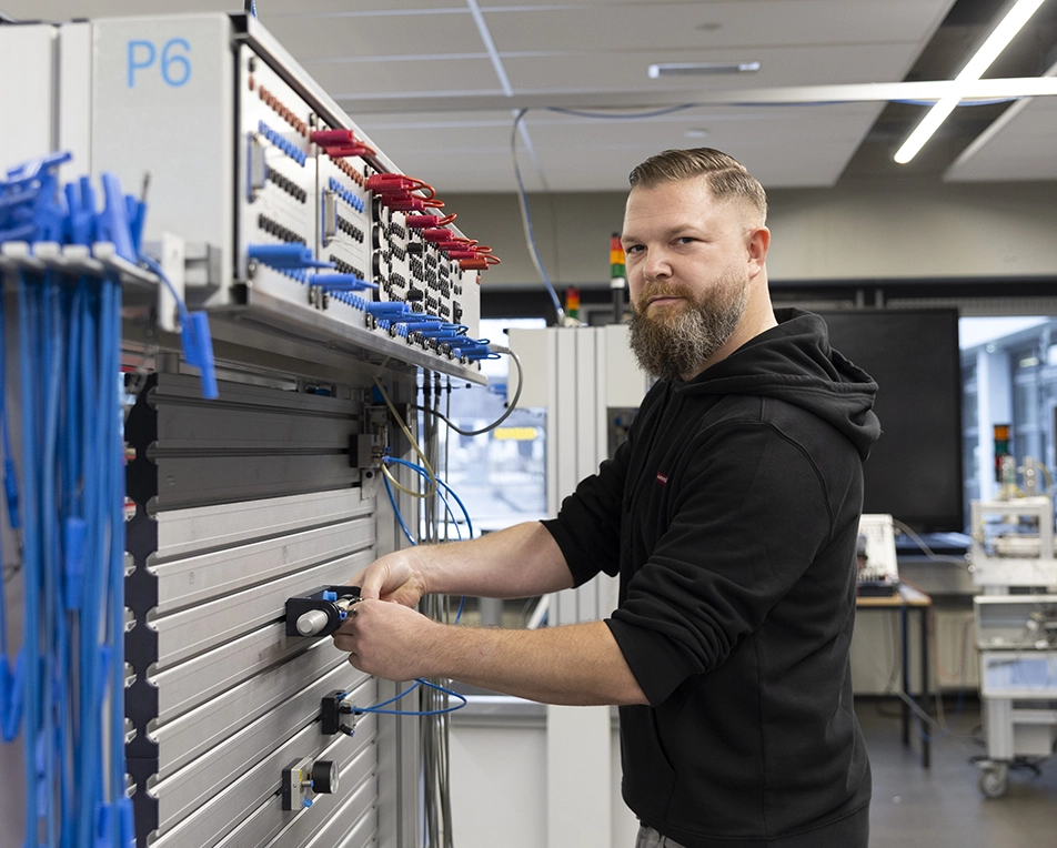 Man in zwarte trui die met kabels bezig is