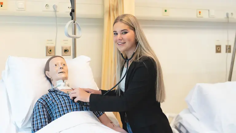 Persoon in ziekenhuis die naar het hard van een patiënt luistert.